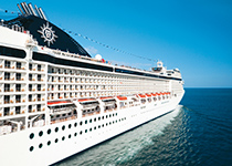 Ett stort kryssningsfartyg från MSC Cruises seglar över det öppna havet under en klarblå himmel.