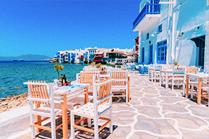 Strandnära restaurang i Mykonos, Grekland med vitkalkade byggnader och havsutsikt.