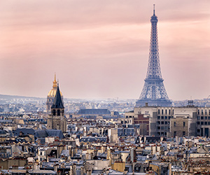 Vy över Paris med Eiffeltornet och stadens silhuett i dämpat kvällsljus.